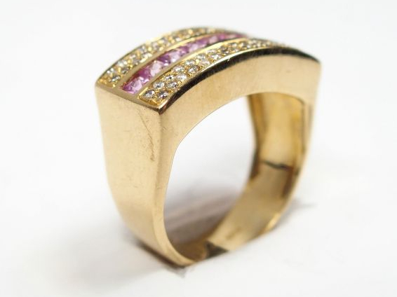 Bague en or jaune, ornée d'une rangée de 9 saphirs roses bordée de 66 