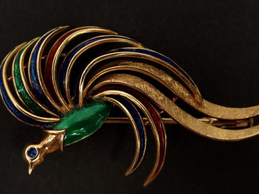Broche en or jaune et émail vert, bleu et rouge, en forme d'oiseau de 