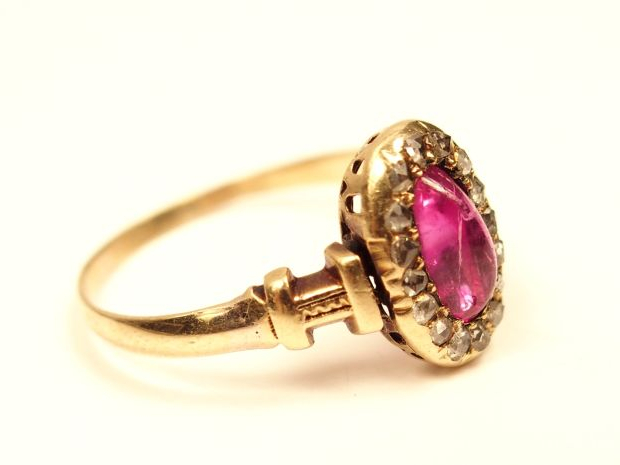 Bague en or jaune, ornée en son centre d'un rubis cabochon entouré de 