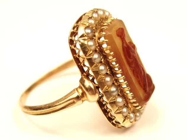 Bague en or jaune, ornée en son centre d'une cornaline figurant une je