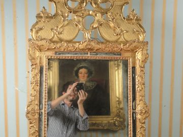 	Glace à parecloses Louis XV en bois sculpté et doré, surmontée d’un f