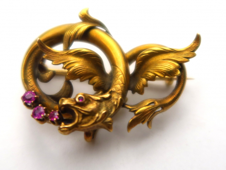 Broche en or représentant un dragon stylisé, orné de pierres roses. Po