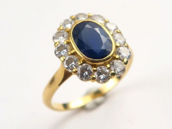 Bague marguerite, saphir serti clos dans un entourage de diamants.  TD