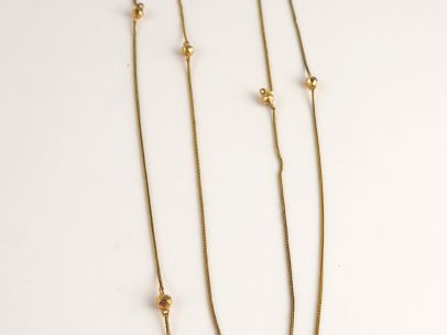 Sautoir en or, alternance de perles en or facetées. Poids : 7 g