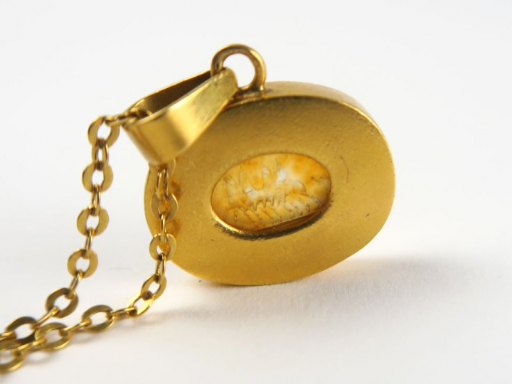 Collier en or composée d'une chaine retenant un pendentif avec une int