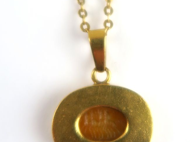 Collier en or composée d'une chaine retenant un pendentif avec une int