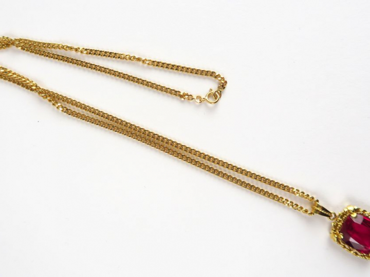 12/ Chaine en or (13 g), retenant un pendentif en or serti d'un rubis 