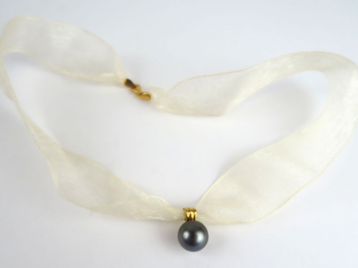 Perle grise montée en pendentif, monture en or, avec son lien.