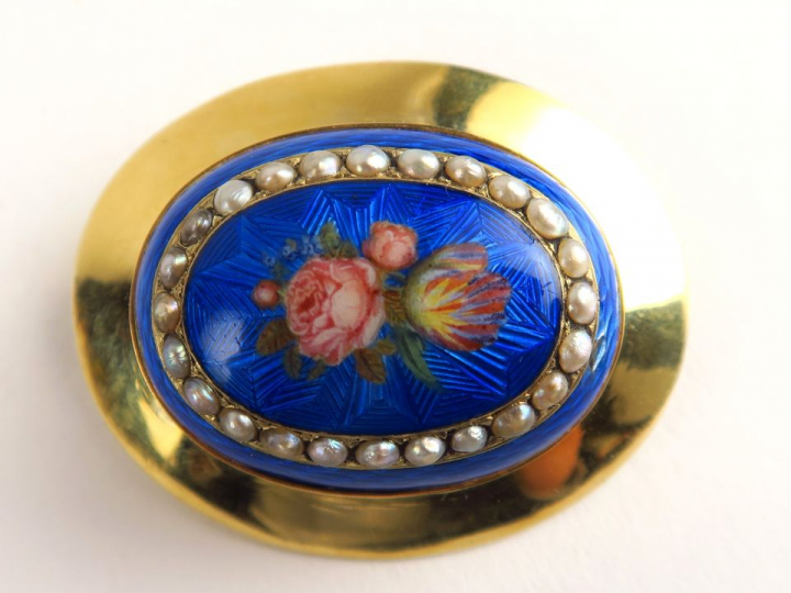 Broche en or, émail polychrome à décor de fleurs sur fond bleu. Dans u