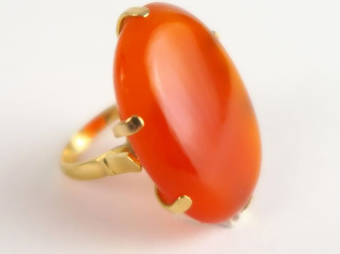 Bague monture en or, ornée d'une pierre orange en cabochon. Poids tel 