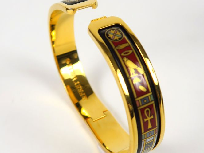 Fery WILLE. Bracelet jonc en métal doré à décor égyptine.