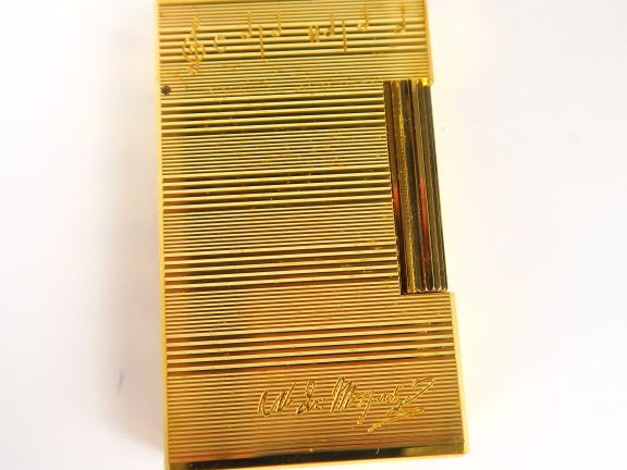 DUPONT. Deux briquets en métal doré, dont un gravé de partitions