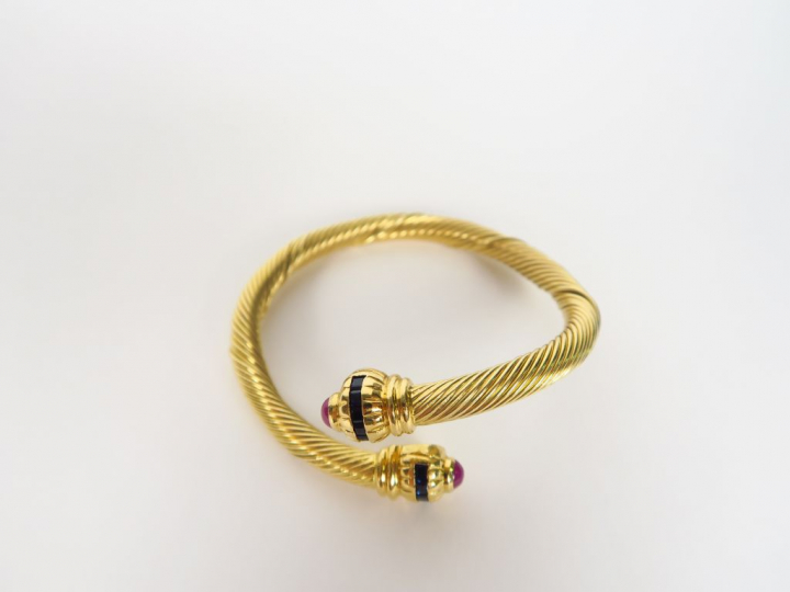 Bracelet torsadé en or jaune, orné de petits saphirs et de rubis en ca