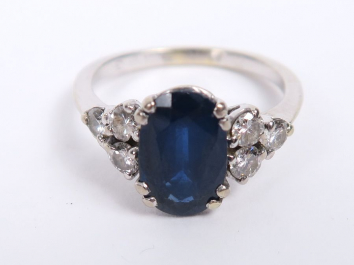 Bague en or blanc, ornée d'un saphir épaulé de trois diamants de chaqu