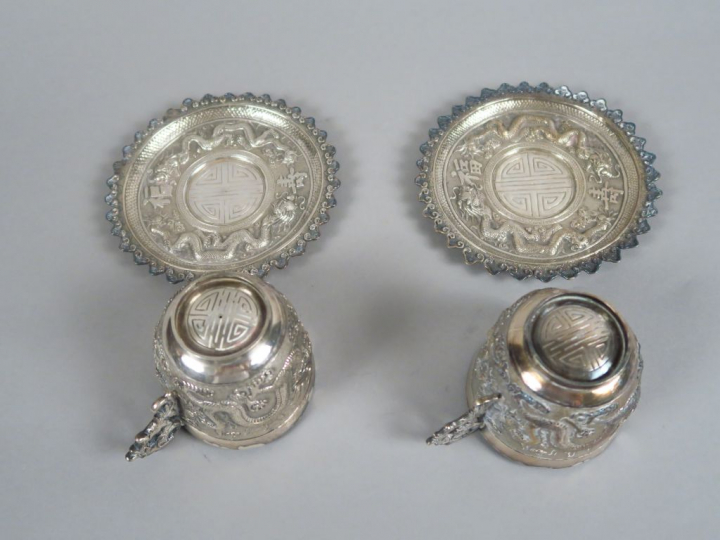 Paire de tasses et sous-tasses en argent bas-titre, à décor finement c