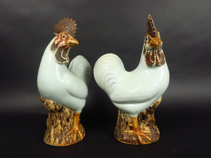 Paire de coqs en porcelaine émaillée blanc et brun, debout sur des roc