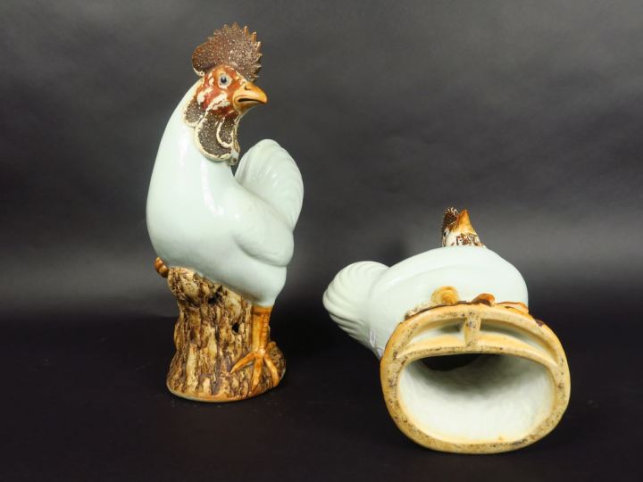 Paire de coqs en porcelaine émaillée blanc et brun, debout sur des roc