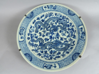 Vente aux enchères Plat en porcelaine bleu blanc, à décor de deux dragons parmi des fleur