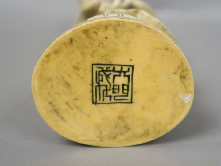 Sujet en ivoire représentant un sage tenant une branche de prunus en f