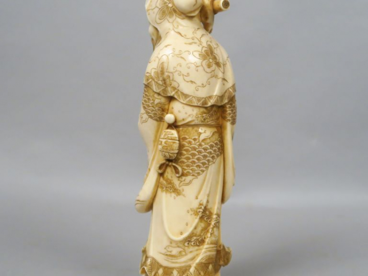 Okimono en ivoire représentant Jurojin tenant un rouleau et une pêche 