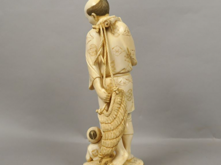 Okimono en ivoire représentant un paysan portant une besace, regardant