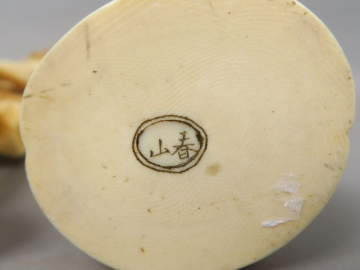 Deux okimonos en ivoire, l’un représentant un pêcheur avec harpon, l’a