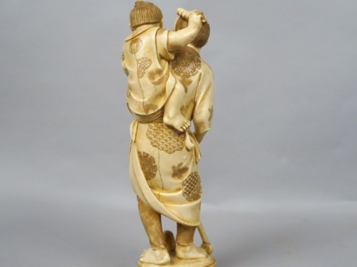 Okimono en ivoire représentant un père et son fils s’amusant avec un j