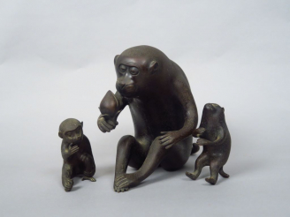 Vente aux enchères Okimono en bronze de patine brune représentant un singe assis, s’apprê