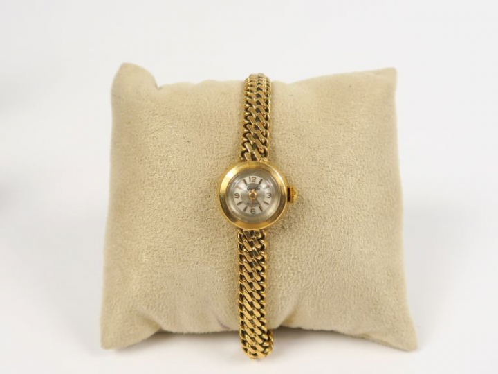 Montre de dame bracelet souple et boitier en or jaune. Cadran signé Ge