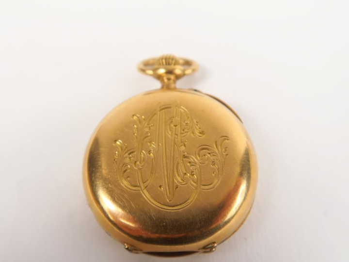 Montre de col en or jaune, fond à décor de monogramme, cadran émaillé.