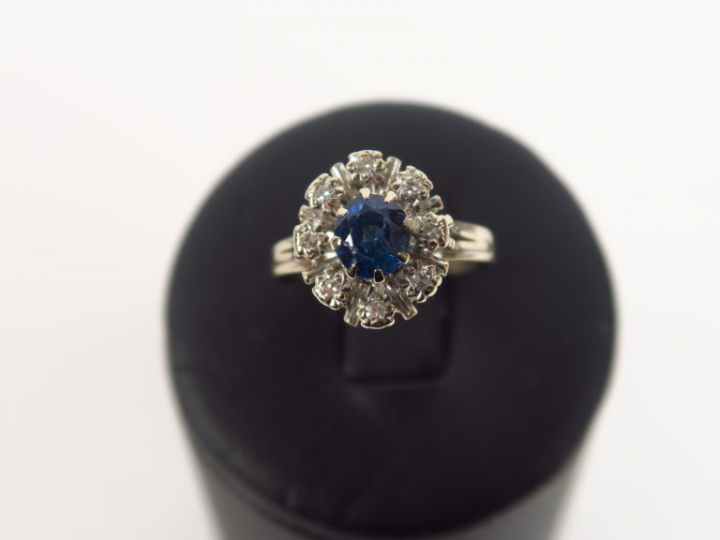 Bague marguerite monture or blanc, ornée d'un saphir entouré de huit b