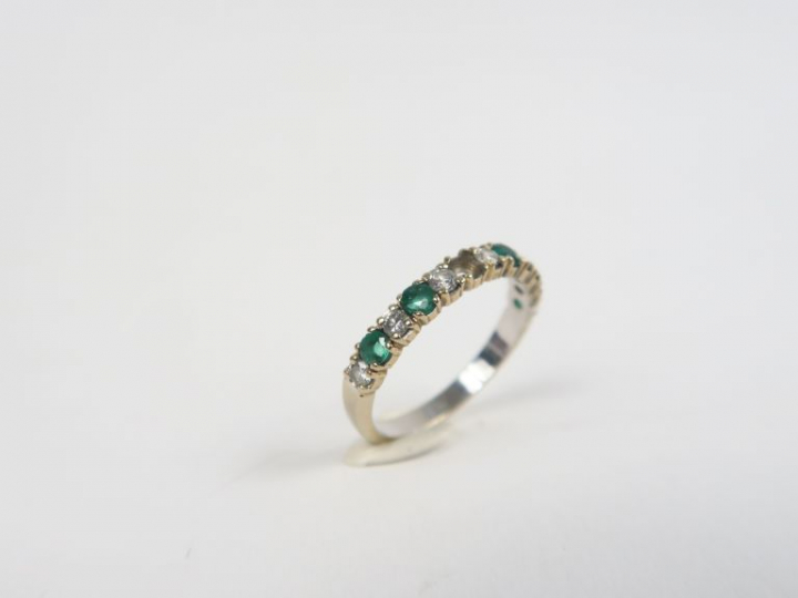 Demi-alliance en or gris, brillants et émeraudes. Poids. 2 g (une émer