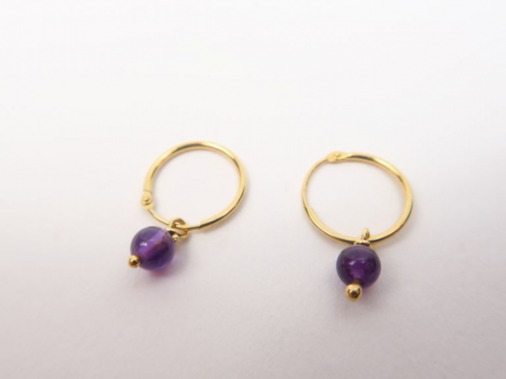 Paire de créoles en or jaune ornées de pierres mauves. Poids. 0,68 g