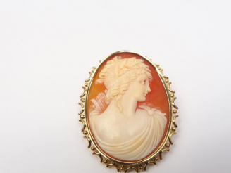 Vente aux enchères Broche ornée d'un camée à décor de profil de jeune fille. Monture en o
