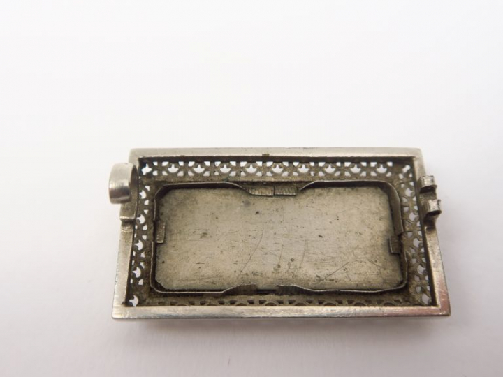 Broche en émail, à décor d'un amour peignant.  On y joint une chaine e