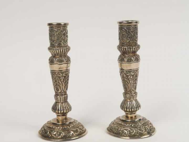 Paire de bougeoirs en argent, à décor au repoussé de feuillage. Poids.