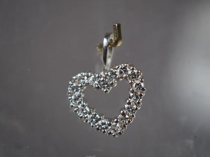 Pendentif en forme de cœur en or blanc, orné de seize petits diamants.