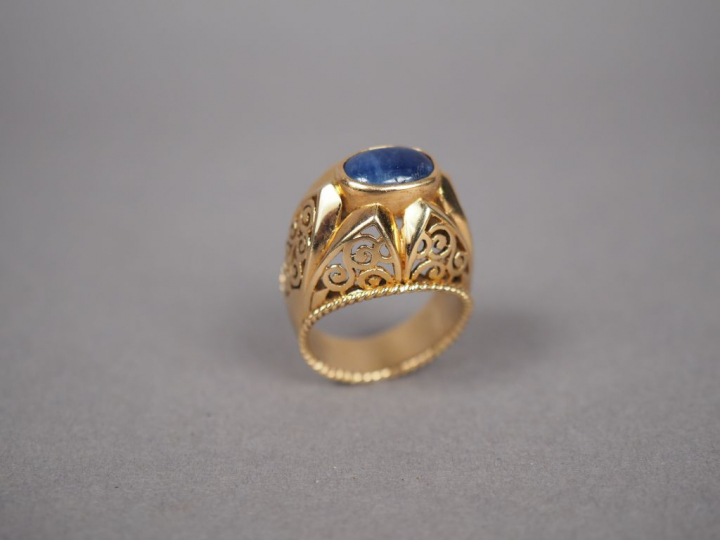 Bague dôme en or jaune, ornée d'une pierre bleue en cabochon.  Monture