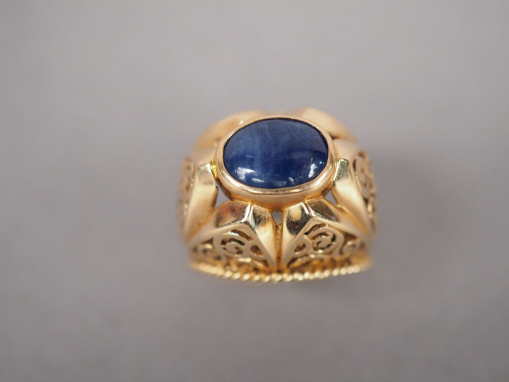 Bague dôme en or jaune, ornée d'une pierre bleue en cabochon.  Monture