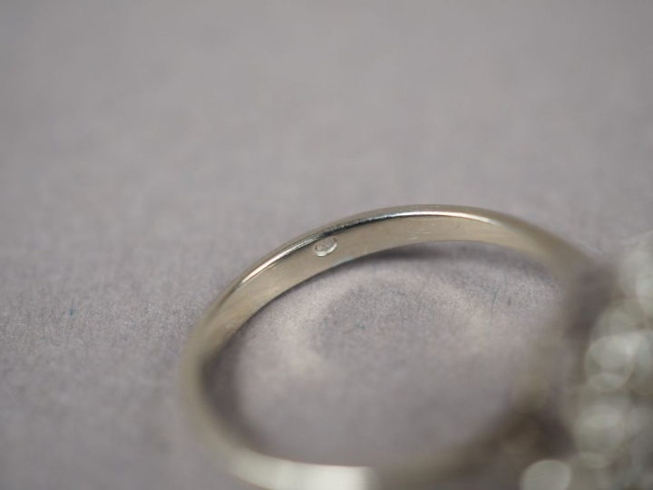 Bague en or blanc, ornée d'un diamant central entouré de petits diaman