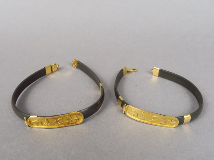 Deux bracelets de style égyptien en caoutchouc et or.  Poids tel. 15,7