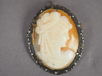 Vente aux enchères Broche/pendentif à décor d'un camée figurant un profil de jeune femme.