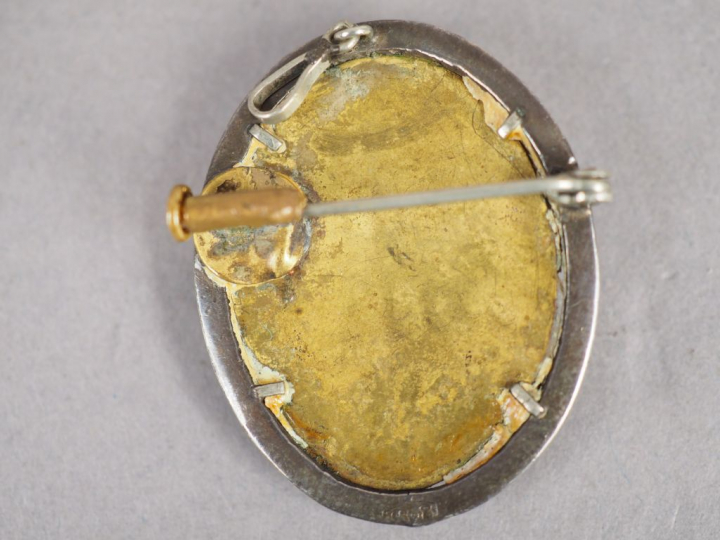 Broche/pendentif à décor d'un camée figurant un profil de jeune femme.
