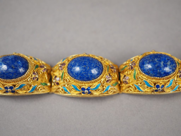 Parure en métal doré, émail et lapis lazuli en cabochon. Comprenant : 