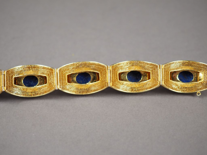 Parure en métal doré, émail et lapis lazuli en cabochon. Comprenant : 