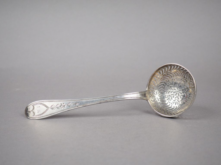 Cuillère à saupoudrer en argent, poinçon au coq, à décor de feuillage,