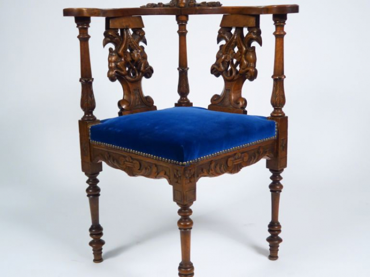 Fauteuil d'angle de style Henri II en noyer mouluré et sculpté à décor