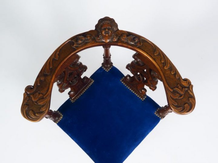 Fauteuil d'angle de style Henri II en noyer mouluré et sculpté à décor