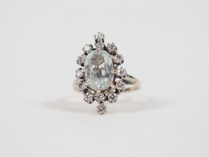 Bague en or blanc, sertie de petits diamants entourant une pierre tran