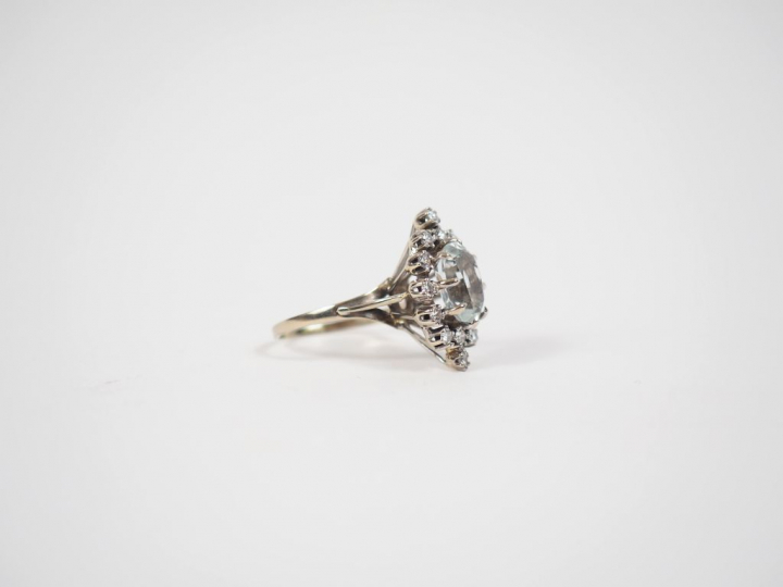 Bague en or blanc, sertie de petits diamants entourant une pierre tran